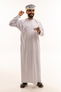 رجل عماني بالزي التقليدي يستخدم عود تنظيف الأذن