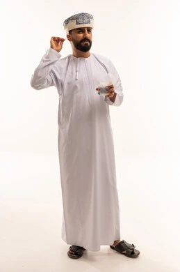 رجل عماني بالزي التقليدي يستخدم عود تنظيف الأذن