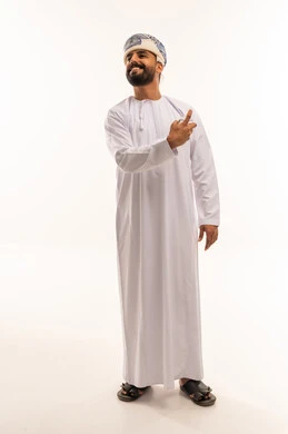 رجل عماني بالدشداشة التقليدية يشير على خلفية بيضاء