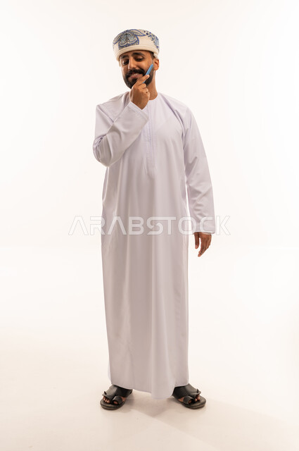 Omani Man Grooming Beard in Traditional White Dishdasha