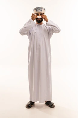 رجل عُماني بالزي التقليدي دشداشة وكمة يبتسم