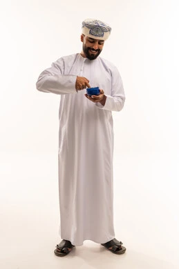 Omani Man in Traditional Dishdasha Holding a Bowl