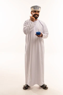 رجل عُماني يضع كريم الوجه للعناية الشخصية