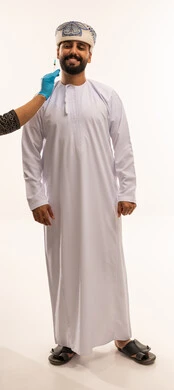 Omani Man Receiving Medical Injection in Traditional Dress