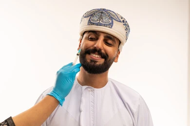 رجل عماني يتلقى حقنة تجميلية في عيادة