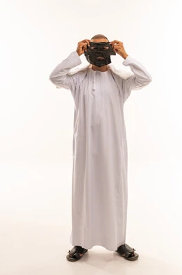 Omani Man Holding Black Charcoal Facial Mask in Studio