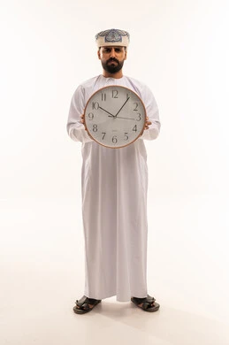 Omani Man in Traditional Dress Holding a Wall Clock