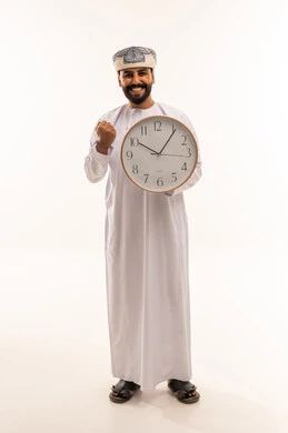 رجل عُماني يمسك بساعة حائط على خلفية بيضاء