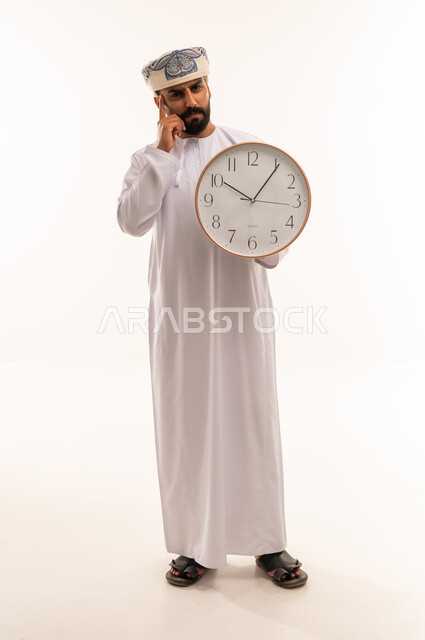 Omani Man in Traditional Dress Holding a Wall Clock