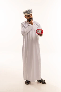 رجل عماني يفكر ويحمل ساعة منبه حمراء