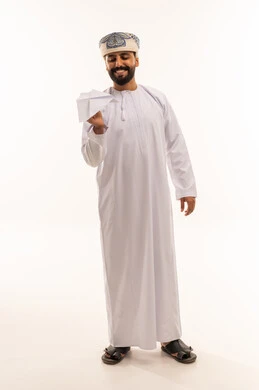 رجل عماني بالزي التقليدي يمسك طائرة ورقية