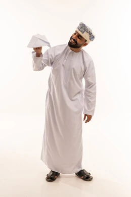 رجل عماني بالزي التقليدي يمسك طائرة ورقية