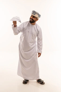 رجل عماني بالزي التقليدي يحمل طائرة ورقية