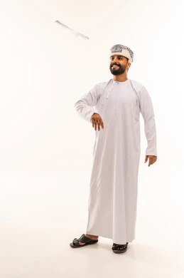Omani Man in Traditional Dress Throwing Paper Airplane