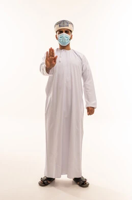 رجل عُماني بالكمامة يؤدي إشارة التوقف خلفية بيضاء