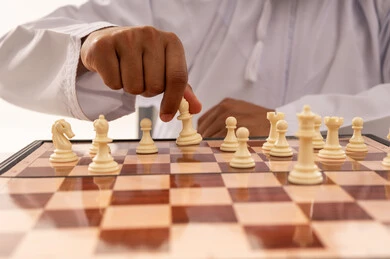 رجل عُماني يلعب الشطرنج لقطة قريبة لليد