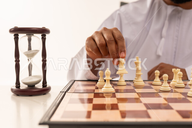 Omani Man Playing Chess Strategy with Hourglass