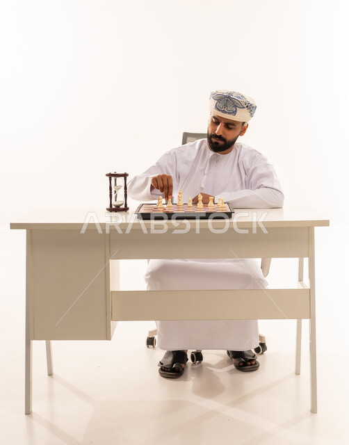 Omani Man Playing Chess with Strategy Hourglass