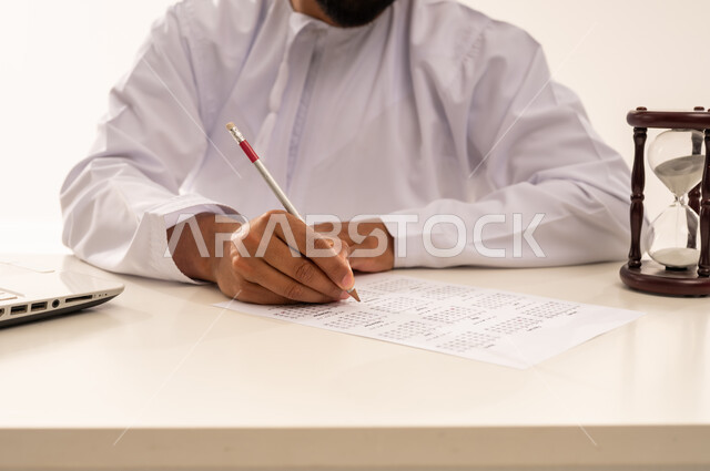 رجل عماني يخطط لجدول زمني مع ساعة رملية