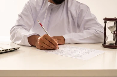 رجل عماني يخطط لجدول زمني مع ساعة رملية