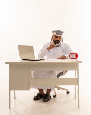 رجل عماني يستخدم عدسة مكبرة في مكتبه