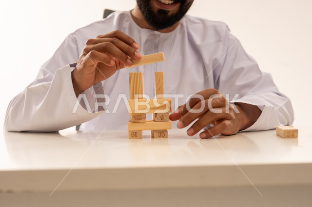 رجل عُماني يبني برجاً بالمكعبات الخشبية في الداخل