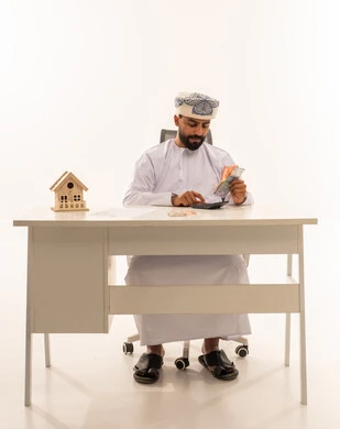 Omani Man Counting Money for House Investment