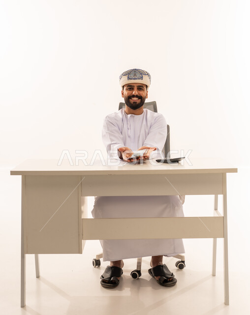 رجل عماني في المكتب يحمل عملات ورقية