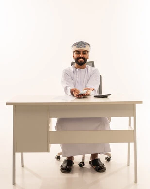 Omani Man at Desk Holding Omani Rial Banknotes