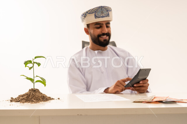 رجل أعمال عماني يحسب الأرباح والاستثمار المالي