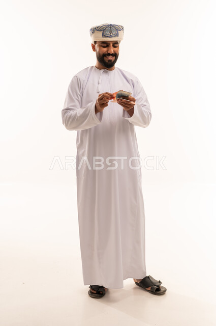 Omani Man in Traditional Dress Counting Money
