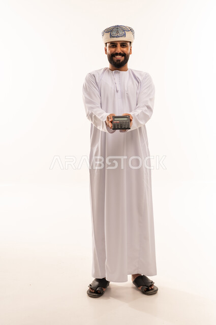Omani Man in Traditional Dress Holding Calculator