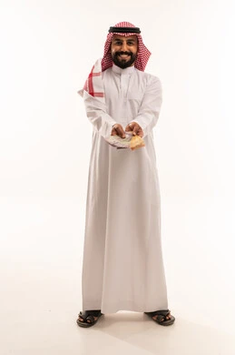 رجل سعودي يمسك أوراقاً نقدية من الريال السعودي