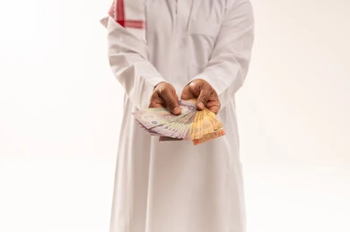 Saudi Man Holding Saudi Riyal Banknotes on White Background