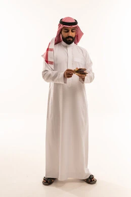 Saudi Man in Traditional Thobe Counting Cash Money