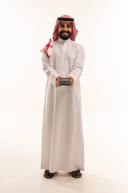 رجل سعودي بالثوب يمسك آلة حاسبة خلفية بيضاء