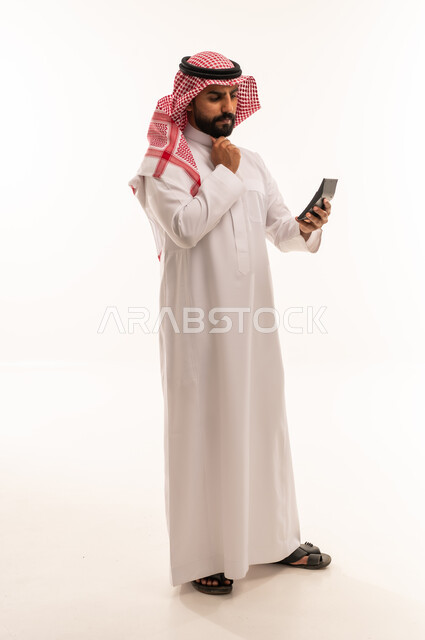 Saudi Man in Thobe Using Calculator on White Background