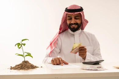Saudi Man with Money and Growing Plant