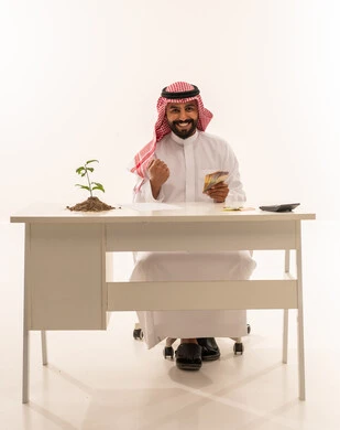 Saudi Businessman Holding Money with Growth Plant