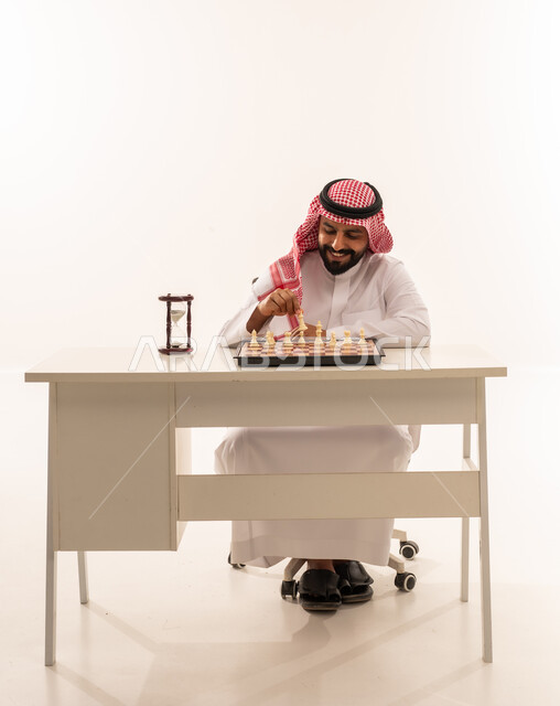 Saudi Man Playing Chess at White Desk with Hourglass