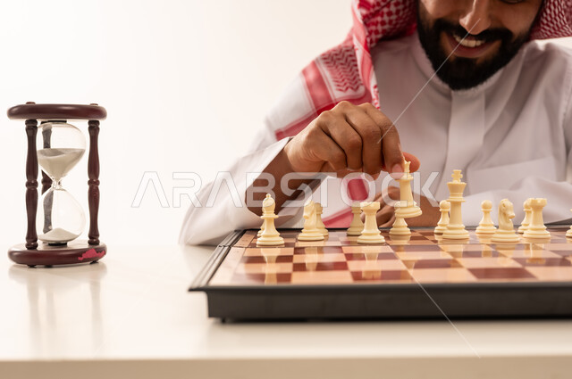 رجل سعودي يلعب الشطرنج مع ساعة رملية