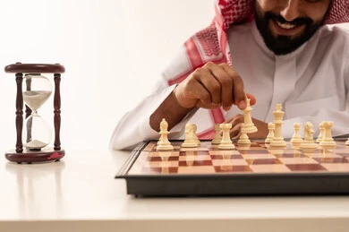 رجل سعودي يلعب الشطرنج مع ساعة رملية
