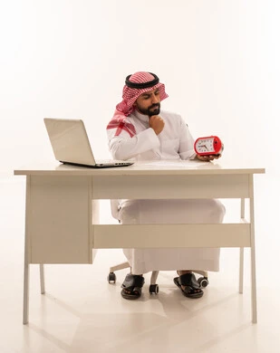 Saudi Businessman at Desk with Red Alarm Clock