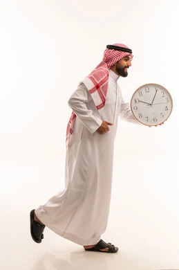 رجل سعودي يركض حاملاً ساعة حائط على خلفية بيضاء