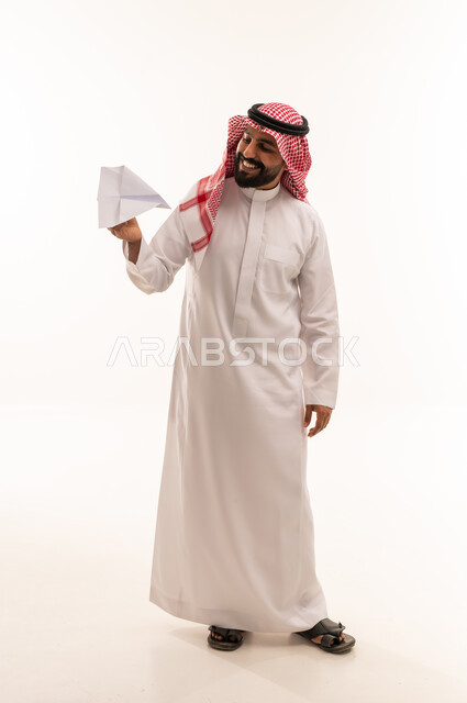 رجل سعودي بالزي التقليدي يحمل طائرة ورقية