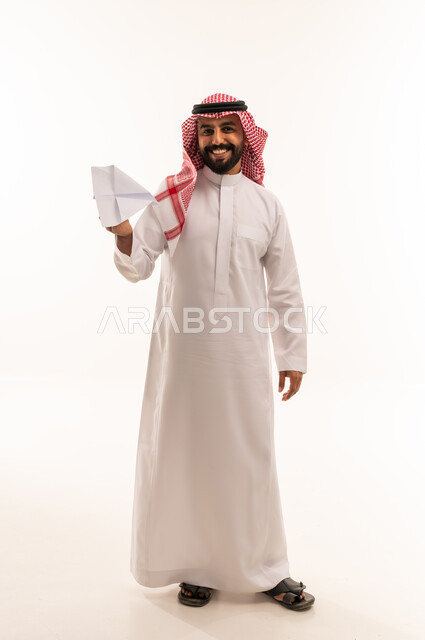 رجل سعودي بالزي التقليدي يمسك طائرة ورقية