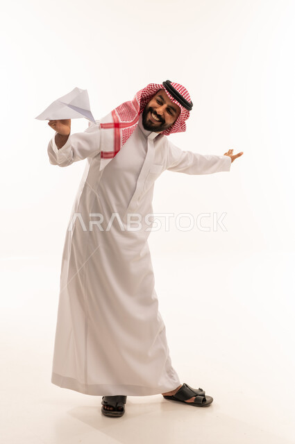رجل سعودي بالثوب التقليدي يحمل طائرة ورقية