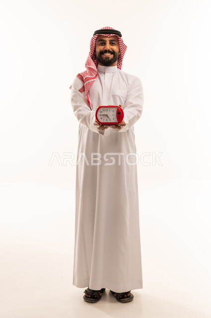 Saudi Man in Thobe Holding Red Alarm Clock