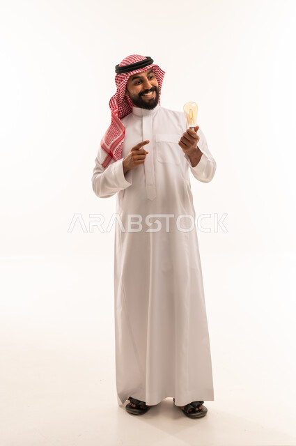 رجل سعودي يحمل مصباحاً كهربائياً على خلفية بيضاء