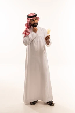 رجل سعودي بالثوب يفكر ويحمل مصباح كهربائي